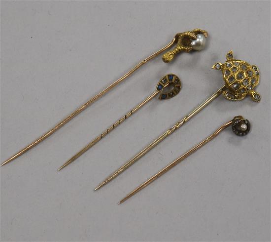 An early 20th century yellow metal and diamond set turtle stick pin and three other stick pins.